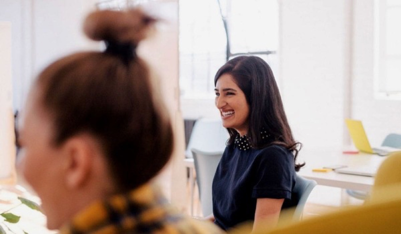 Advisor laughing with a client in an open-plan office